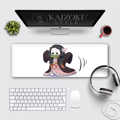This desk mat showcases an adorable chibi version of Nezuko Kamado from *Demon Slayer: Kimetsu no Yaiba*. The minimalist white background accentuates the cute, expressive design of Nezuko in her iconic outfit with her bamboo muzzle. It's a perfect addition for fans of *Demon Slayer* who enjoy playful and charming artwork.